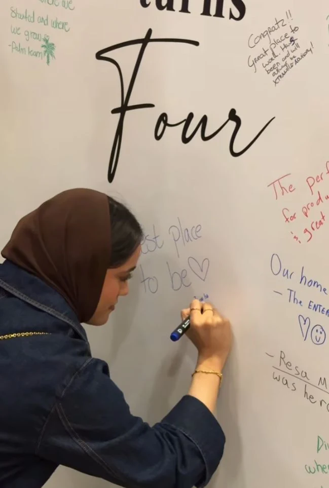 A guest writing on a wall during a Diwan Hub event.