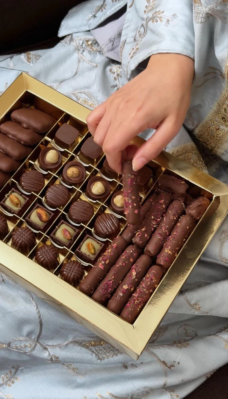 Chocolates selected by hand from a presentation box.